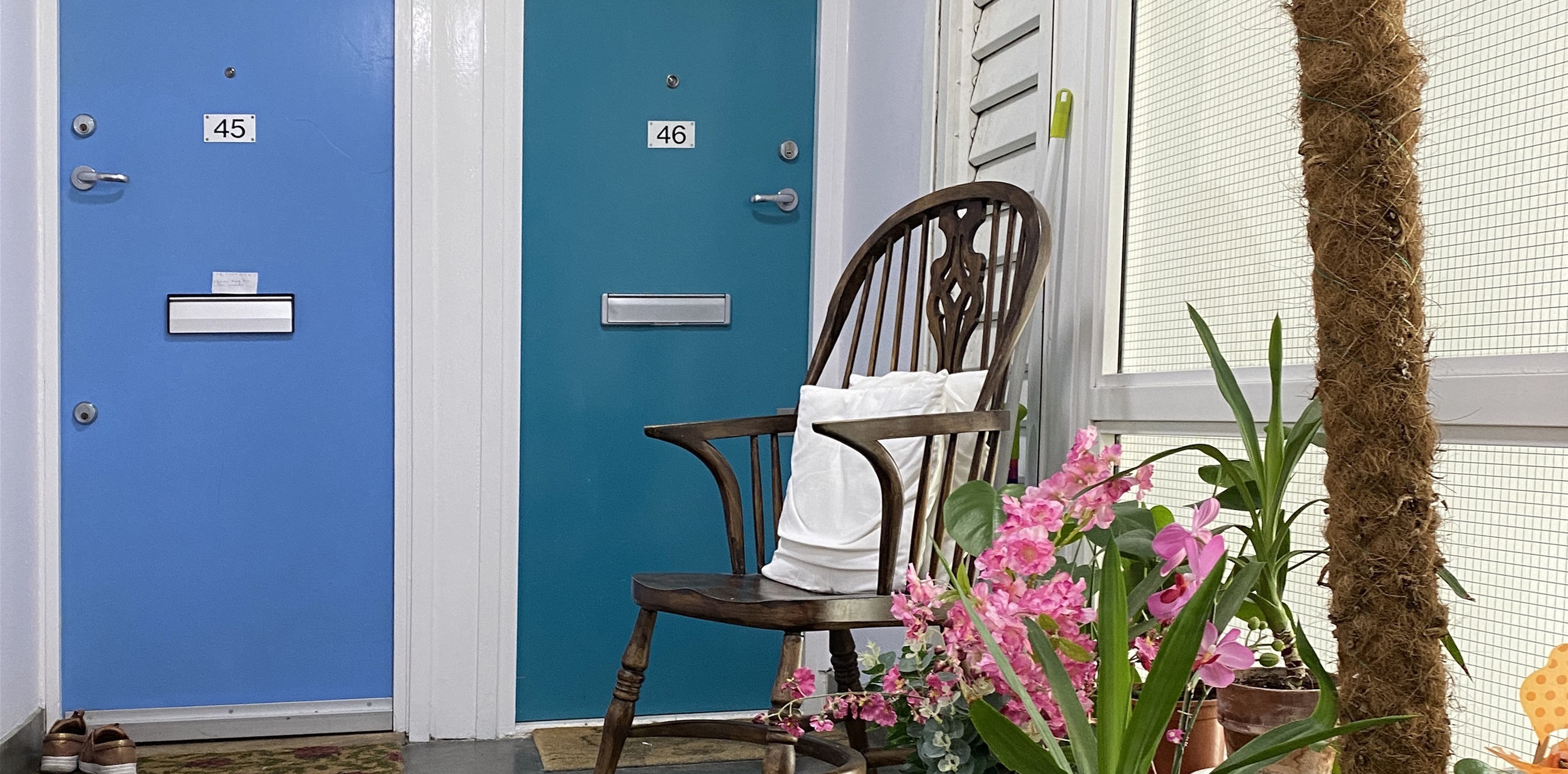 two front doors to flats with a homely seating area and pot plants outside