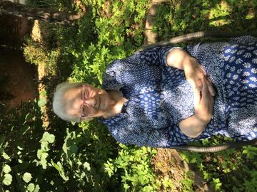 lidia sciama - an older woman sitting in a sunny garden